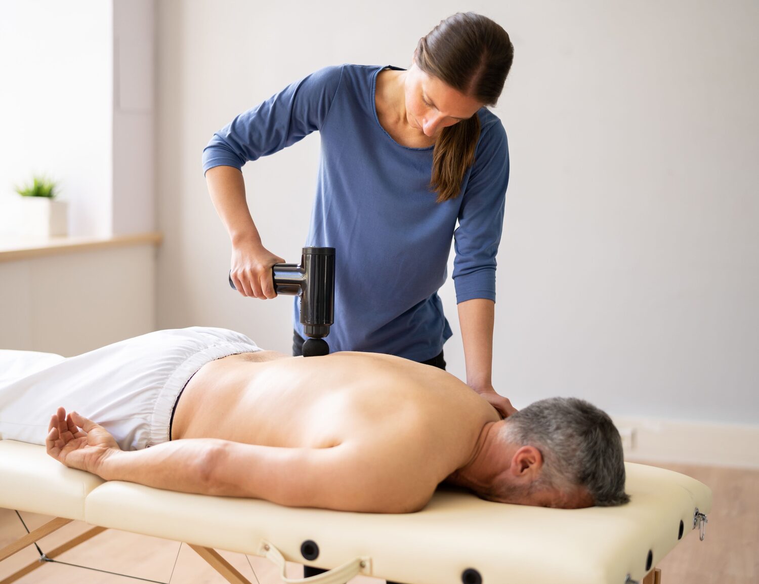 kine patient massage avec pistolet